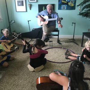 Small children learning guitar