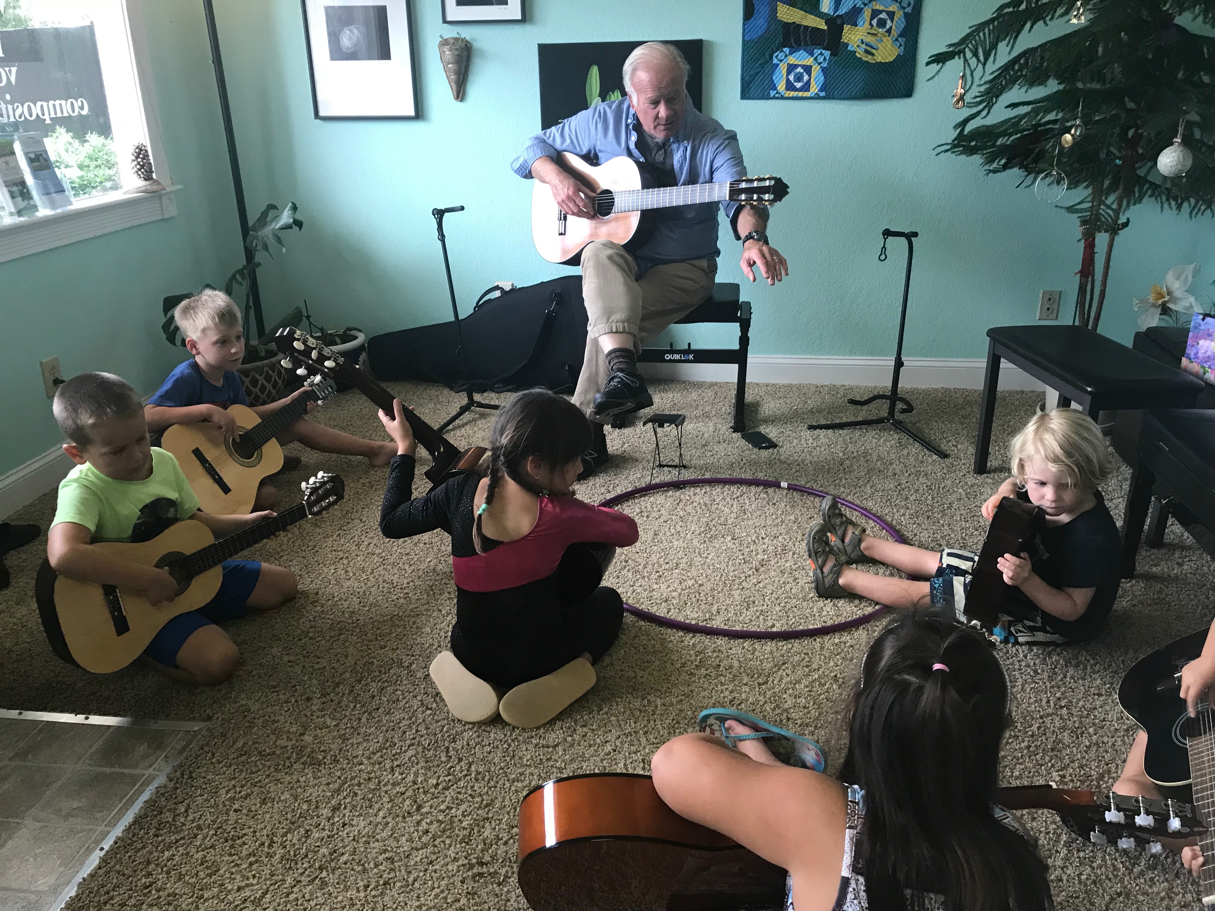 Small children learning guitar